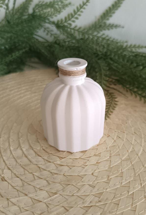 Petit vase diffuseur de parfum blanc.