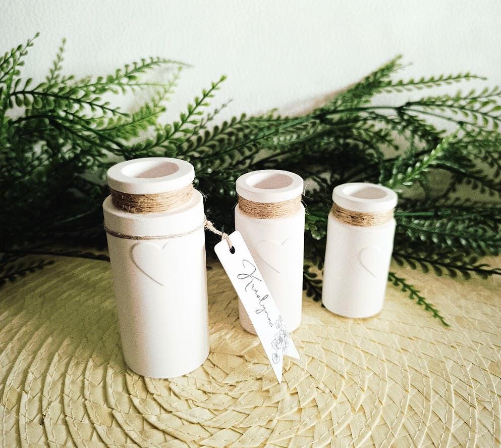 Trois petits vases décoratifs blancs.