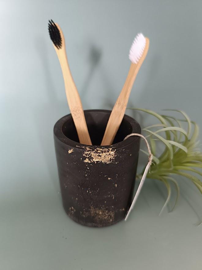 Pot rangement brosses à dents noir et or.