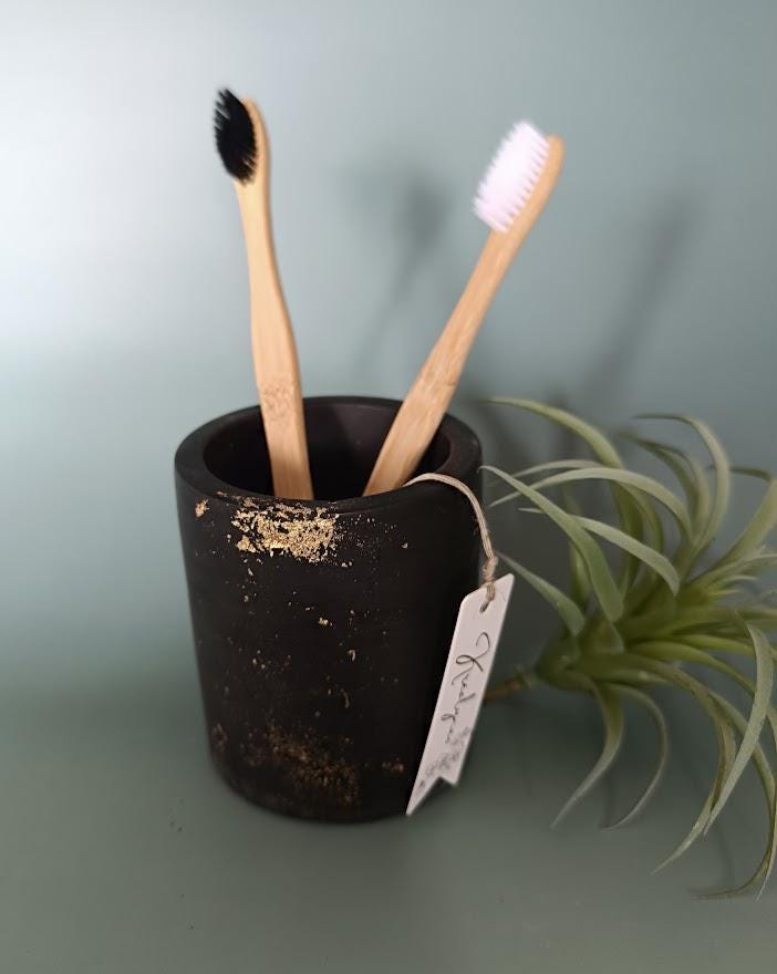 Pot rangement brosses à dents noir et or.