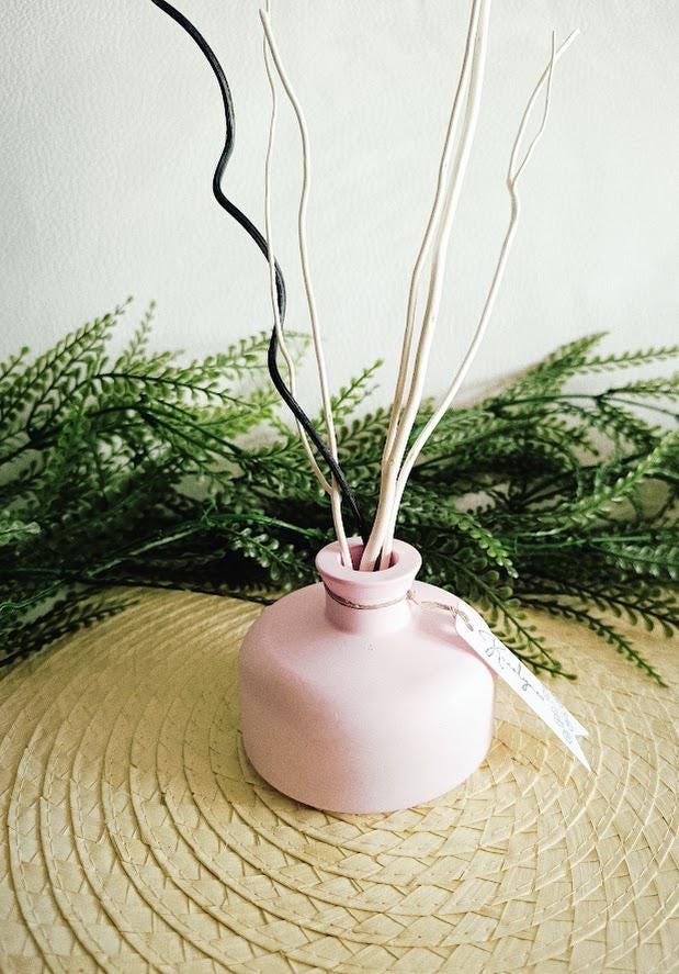 Petit vase diffuseur de parfum rose pâle.